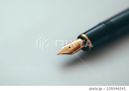 Elegant fountain pen rests on a smooth white surface ready for writing in a quiet workspace Elegant fountain pen rests on a smooth white surface ready for writing in a quiet workspace 129344241