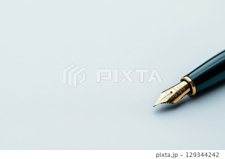 Elegant fountain pen poised on pristine white surface during a creative writing session 129344242