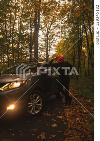Autumn SUV with Driver with Pumpkin Head in Forest 129345182