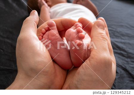 Tender Moment: Holding Newborn Baby Feet 129345212