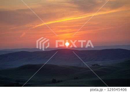 Sun rises over a picturesque mountain valley 129345406