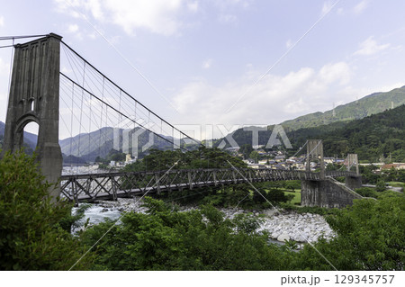 長野県南木曽町に架かる歴史的な吊り橋桃介橋と山並みの風景 長野県南木曽町に架かる歴史的な吊り橋桃介橋と山並みの風景 129345757