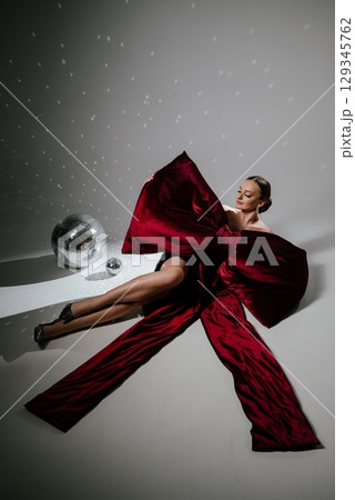 Elegant Woman in Red Dress with Disco Ball Elegant Woman in Red Dress with Disco Ball 129345762