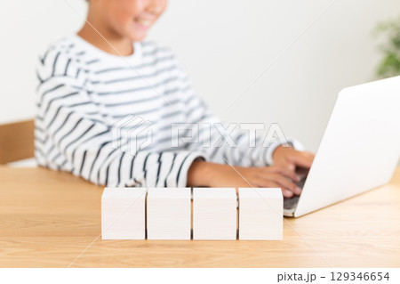 家でパソコンをする小学生の男の子と白いブロック 家でパソコンをする小学生の男の子と白いブロック 129346654
