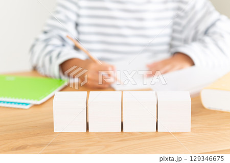 家で宿題をする小学生の男の子と白いブロック 129346675
