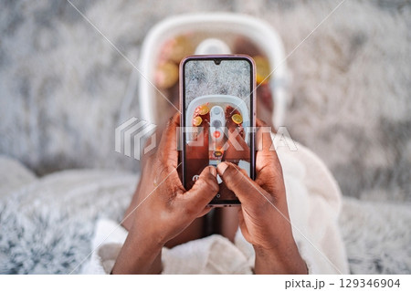 Woman taking photo of feet in foot bath with smartphone Woman taking photo of feet in foot bath with smartphone 129346904