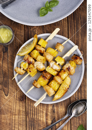 Fried scallops with pineapple on plate. 129347099