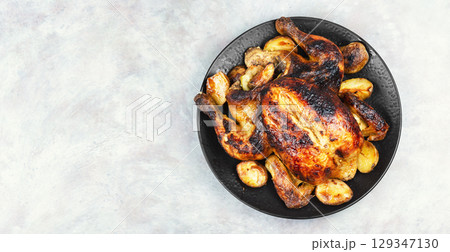 Roasted, baked chicken with potatoes and apples. Roasted, baked chicken with potatoes and apples. 129347130