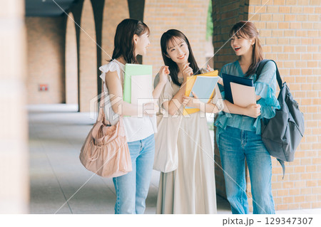 キャンパスを歩く3人の大学生 129347307