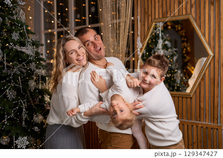 Happy young family parents and children gathering together on Christmas. Cheerful family of four in Happy young family parents and children gathering together on Christmas. Cheerful family of four in 129347427
