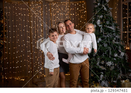 Happy young family parents and children gathering together on Christmas. Cheerful family of four in Happy young family parents and children gathering together on Christmas. Cheerful family of four in 129347481
