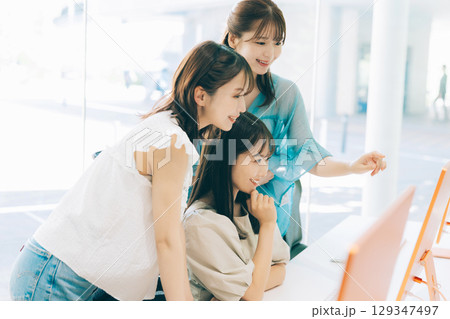 パソコンを見る3人の女性 129347497