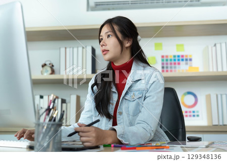 Focused Work. Young woman concentrating on digital design at her computer. 129348136