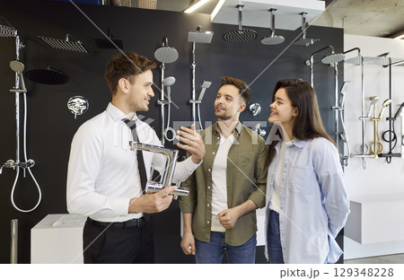 Store Assistant Helping Young Couple Choose Bathroom Faucet Store Assistant Helping Young Couple Choose Bathroom Faucet 129348228