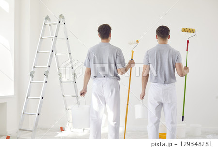 Back two painters in uniform look at the wall, close-up Back two painters in uniform look at the wall, close-up 129348281