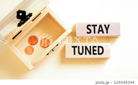 Stay tuned symbol. Concept words Stay tuned on wooden blocks on a beautiful white background. Wooden chest with coins. Business, support, motivation, psychological and stay tuned concept. Copy space. 129348344