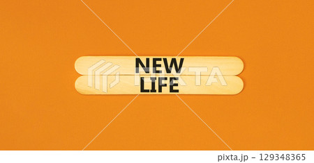 New life symbol. Concept words New life on beautiful wooden stick on a beautiful orange table orange background. Business, support, motivation, psychological and new life concept. Copy space. 129348365