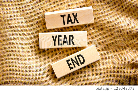 Tax year end symbol. Concept words Tax year end on beautiful wooden blocks. Beautiful canvas table canvas background. Business tax year end concept. Copy space. 129348375