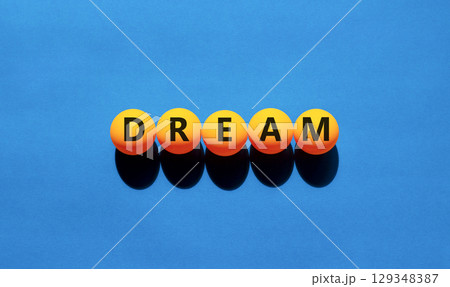 Dream symbol. Concept word Dream on beautiful yellow tennis ping pong balls. Beautiful wooden table wooden background. Business lifestyle dream concept. Copy space. Dream symbol. Concept word Dream on beautiful yellow tennis ping pong balls. Beautiful wooden table wooden background. Business lifestyle dream concept. Copy space. 129348387