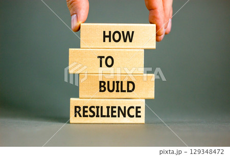 How to build resilience symbol. Concept words How to build resilience on beautiful wooden blocks. Beautiful grey background. Businessman hand. Business and how to build resilience concept. Copy space. How to build resilience symbol. Concept words How to build resilience on beautiful wooden blocks. Beautiful grey background. Businessman hand. Business and how to build resilience concept. Copy space. 129348472