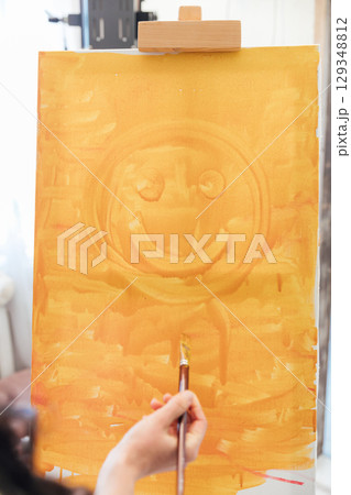 artist paints a picture on easel with brushes artist paints a picture on easel with brushes 129348812