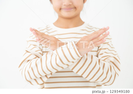 手でバツポーズをする中学生の女の子 129349180