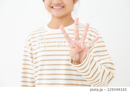 4本指を立てる中学生の女の子 129349183