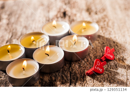 Burning candles sparkle like stars on a dark surface Burning candles sparkle like stars on a dark surface 129351134
