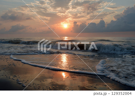 Beach sunrise with soft pastel colors reflecting on calm ocean 129352004