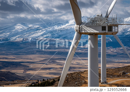 Close-up view of wind turbine tower with mountain backdrop 129352666