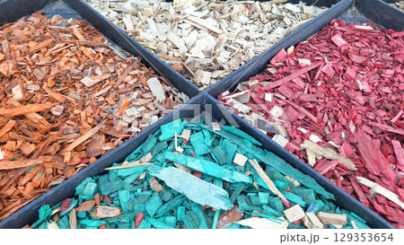 Colorful mulch chips in black compartments: red, green, orange, natural wood tones Colorful mulch chips in black compartments: red, green, orange, natural wood tones 129353654