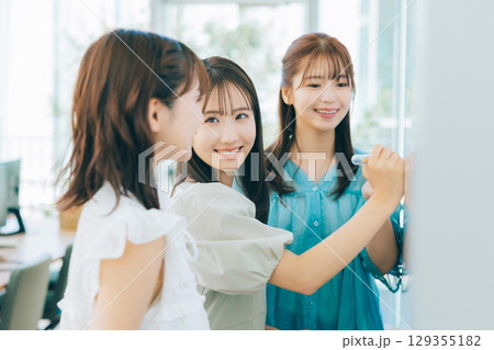 ホワイトボードを使って打ち合わせをする女性チーム　　　 129355182