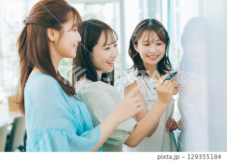 ホワイトボードを使って打ち合わせをする女性チーム　　　 129355184