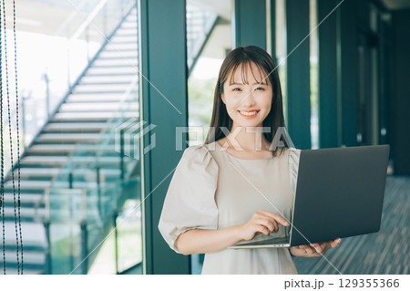 パソコンを持つ若い女性 129355366