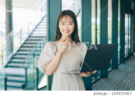 パソコンを持つ若い女性 129355367