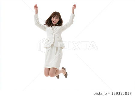 全身で喜びを表現する女性｜白背景でジャンプするビジネスウーマンの笑顔 129355817