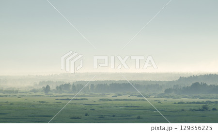 Beautiful misty countryside view of forests at a distance in the morning. Bright landscape of forests in fog in the morning 129356225
