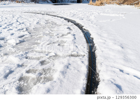 Close up of giant ice circle rotating in river. Rare natural occurrence - perfect ice circle on river in cold winter time Close up of giant ice circle rotating in river. Rare natural occurrence - perfect ice circle on river in cold winter time 129356300