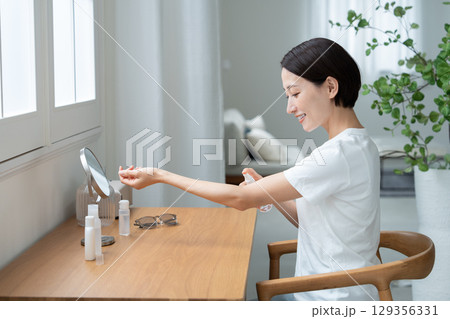 腕にUVケアする女性 腕にUVケアする女性 129356331