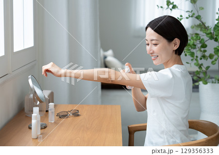 腕にUVケアする女性 腕にUVケアする女性 129356333
