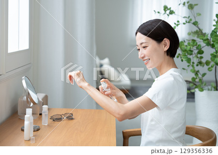 腕にUVケアする女性 129356336