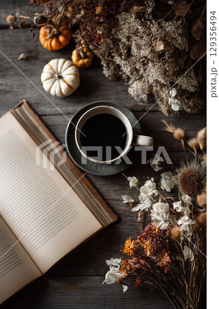 秋の読書とコーヒーの時間｜木製テーブルに広がる温もりの静物写真 129356494