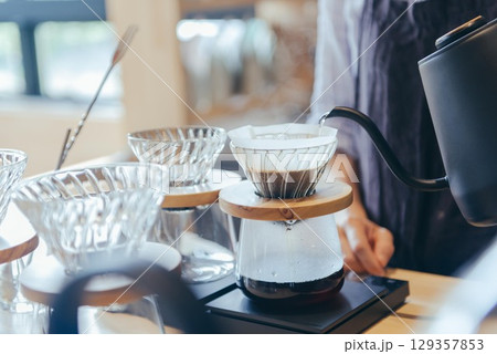 コーヒーをドリップ、ドリッパーにお湯を注ぐ 129357853