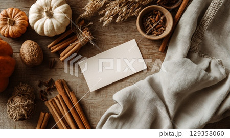 Rustic autumn scene showcasing a card alongside cinnamon, floral touches, tea, and candlelight Rustic autumn scene showcasing a card alongside cinnamon, floral touches, tea, and candlelight 129358060