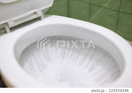 Flushing lavatory pan in toilet. Cleaning toilet after using with water flushing 129359246