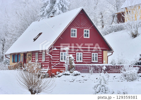 Traditional wooden cottage in a frozen landscape 129359381
