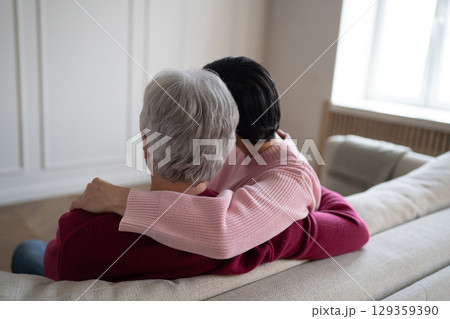 Tender senior couple hugging stroking on sofa. Romantic family warmth comfort emotional relationship 129359390