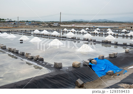Salt mounds form in evaporation pools near Asian village using natural sun drying in rural area Salt mounds form in evaporation pools near Asian village using natural sun drying in rural area 129359433