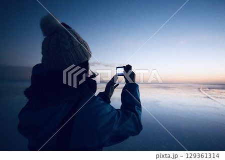 ウユニ塩湖の朝焼けを撮影する女性 129361314