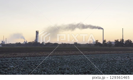 Heavy gray smoke is poured from the chimney pipes of thermal power plant. Carbon dioxide emitting from chimneys from industrial factory into the atmosphere. Concept of environmental pollution problem Heavy gray smoke is poured from the chimney pipes of thermal power plant. Carbon dioxide emitting from chimneys from industrial factory into the atmosphere. Concept of environmental pollution problem 129361465